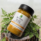 AM Wellness Immunity Booster supplement jar on a wooden stump with plants